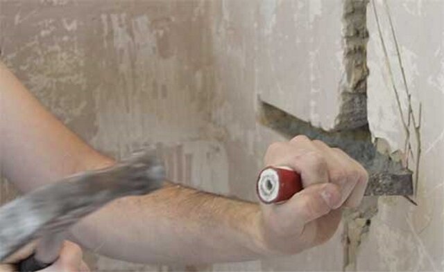 Shtroblenie Wand mit einem Hammer und Meißel