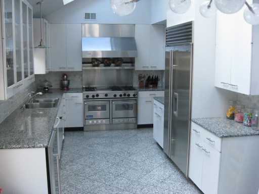 Das Foto zeigt eine klassische Designoption: eine graue Küche und weiße Möbel.