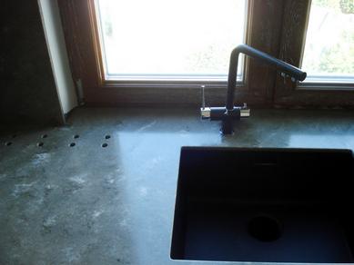 Die Tischplatte ist eine Fensterbank mit eingebautem Waschbecken und Öffnungen für die Luftkonvektion.