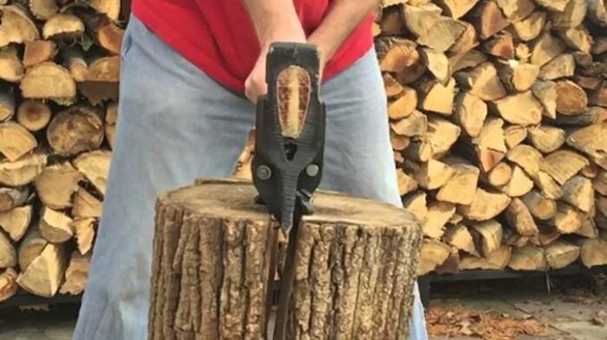 Ax, die mit dem Spanreiß Holz meistert auf einer-zwei